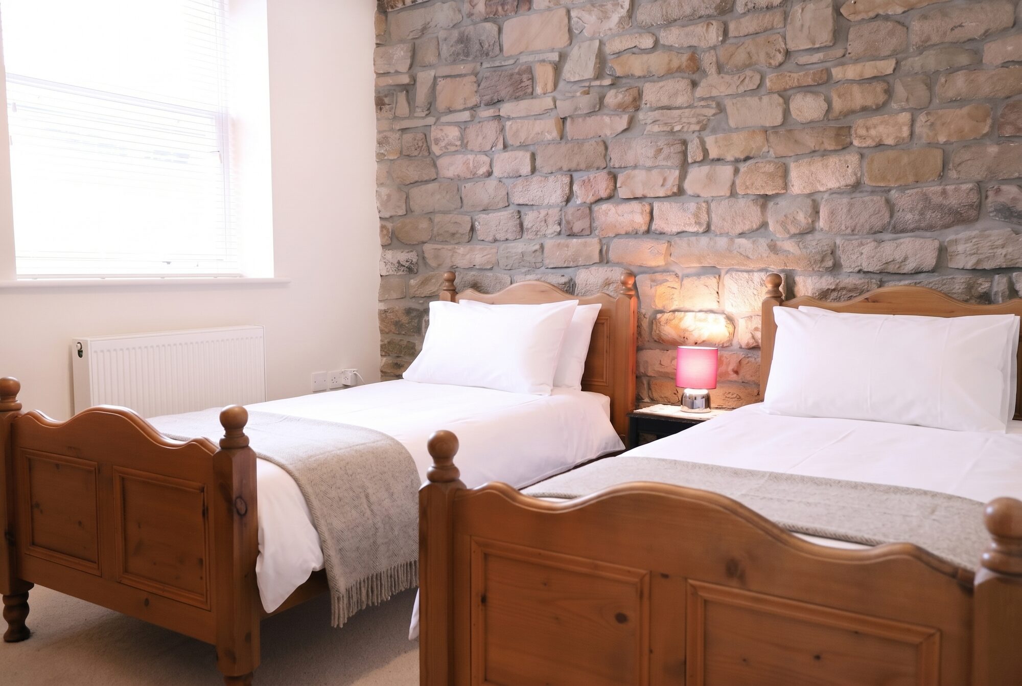 Twin bedroom with exposed stone wall
